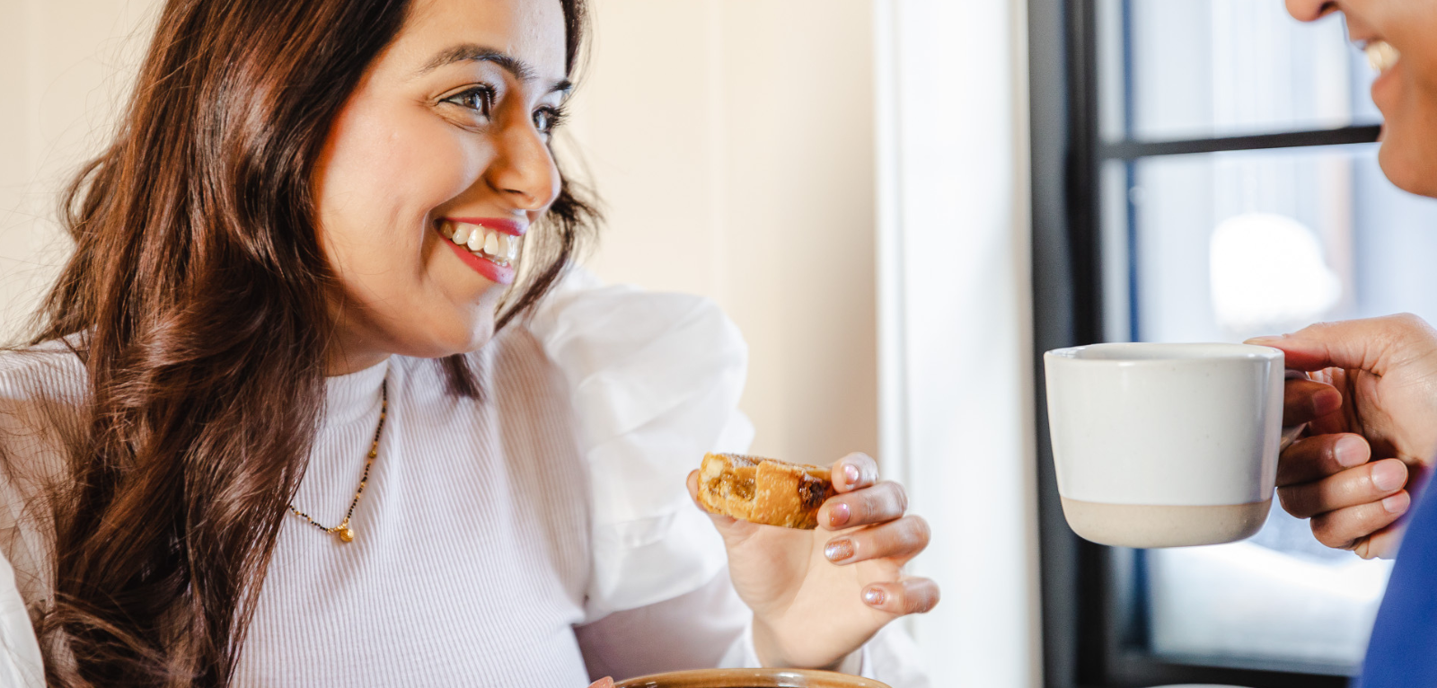 Women smiling while eating a tart